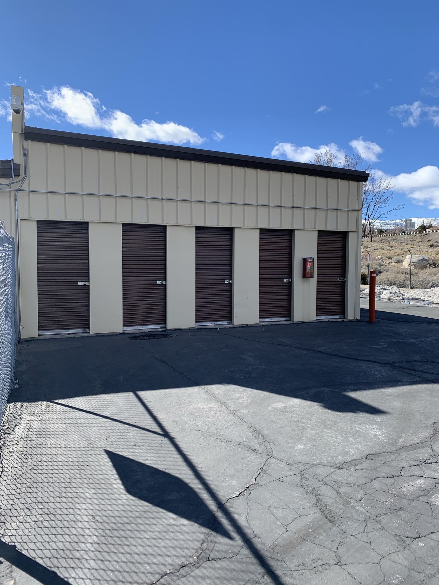 A row of storage units in an empty parking lot.