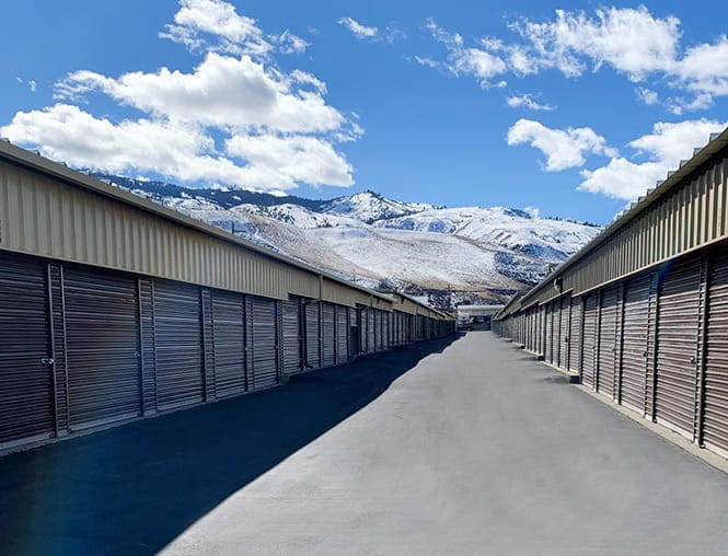 A long road with many buildings and mountains in the background