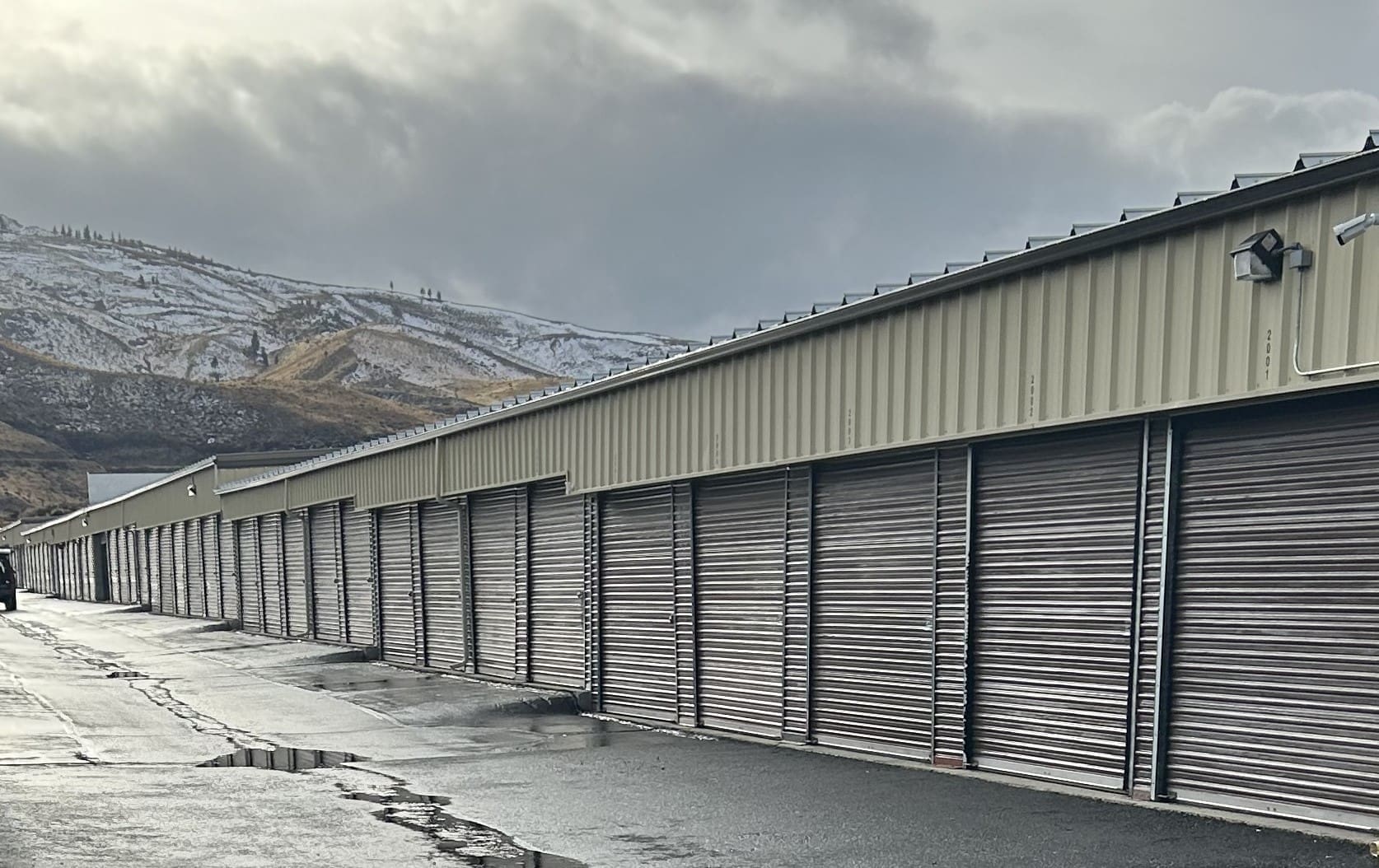 A row of storage buildings with mountains in the background.